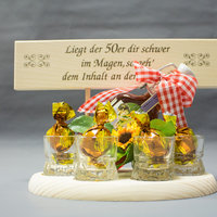 Geschenkarrangement für runden Geburtstag mit Süßigkeiten in kleinen Gläsern auf Holzbrett
